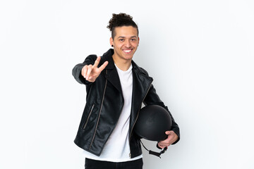 Caucasian man with a motorcycle helmet over isolated white background smiling and showing victory sign