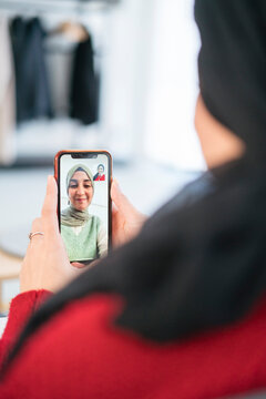 Muslim woman making video call to sister