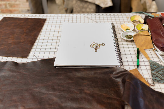 Notebook and leather on work table