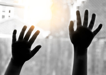 Black and white photo of kid hands showing for help next to glass window, Children asking for help,...