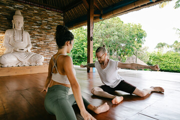 Yoga Teacher Stretching With Student in Private Class