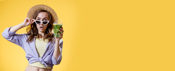 Surprised Woman Drink Mojito cocktail From Plastic Cup Over Yellow Studio Background