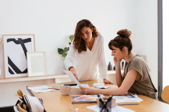 Female colleagues discussing design project in workplace