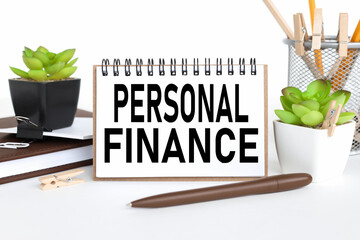 Personal finance. a notebook on a work table, near a flowerpot and a glass with pencils