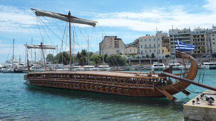 Athenian Trireme masterpiece replica "OLYMPIAS"of ancient warship of 5th BC century, moored at port and Marina of Zea next to busy port of Piraeus, Attica, Greece © aerial-drone