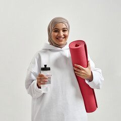 Portrait of arabian girl holding mat and water bottle