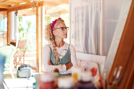 Senior woman looking at a canvas in her studio