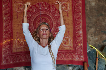 Senior woman practicing yoga at a retreat 