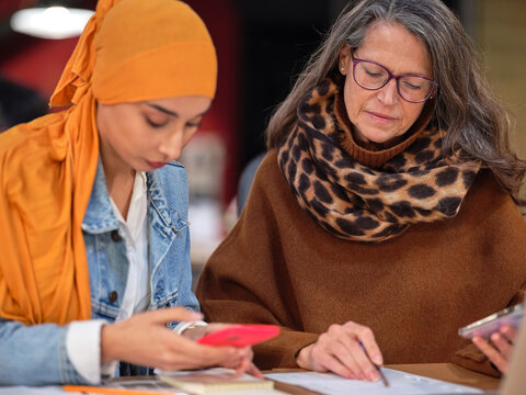 Two female coworkers working with statistic.