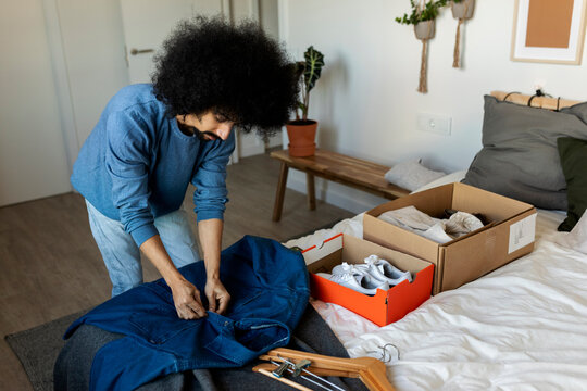 afro hair man folding clothes