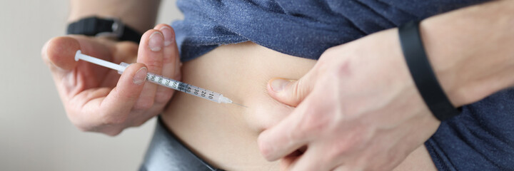 Man injects himself in stomach with an injection of insulin