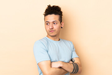 Caucasian man over isolated background keeping the arms crossed