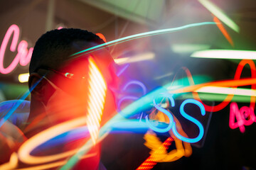 Blurred man in mask in room with neon illumination