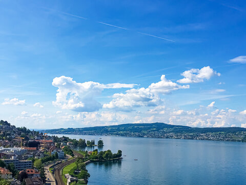 Idyllic Swiss landscape, view of lake Zurich in Richterswil, Switzerland, mountains, blue water of Zurichsee, sky as summer nature and travel destination, ideal as scenic art print.