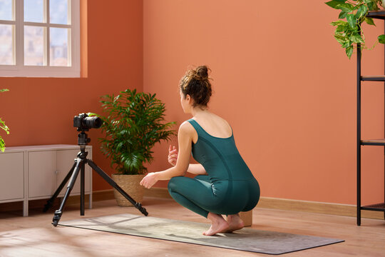 Woman filming online yoga tutorial