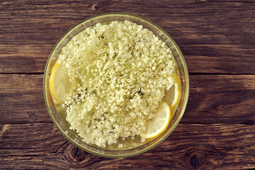 Macerating elder flowers in water to prepare herbal syrup, top view