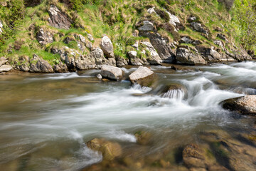 Naklejka na ściany i meble Long exposure of the River Heddon flowing into Heddons Mouth on the north Devon coast