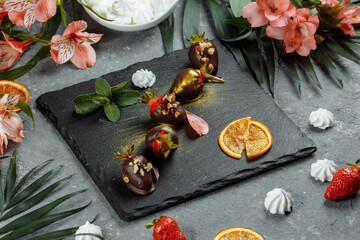Fresh chocolate covered strawberries on a gray decorative background. Concept for advertising the summer seasonal menu