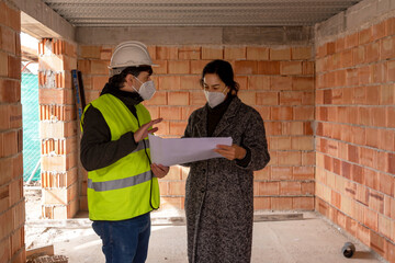 Builder and client discussing draft of new house