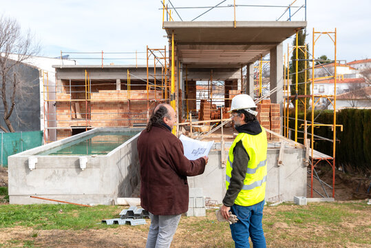 Engineer and architect discussing construction project near building