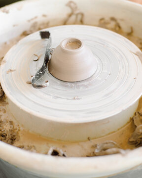 Clay cup on the pottery wheel machine 
