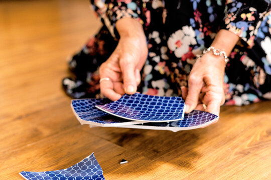 Close-up of woman picking up a broken plate 