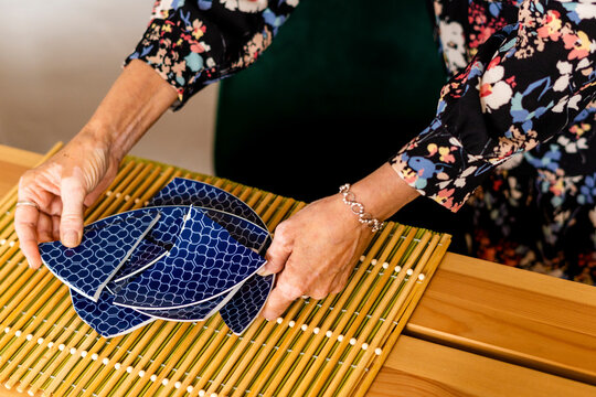 Close-up of woman picking up a broken plate 