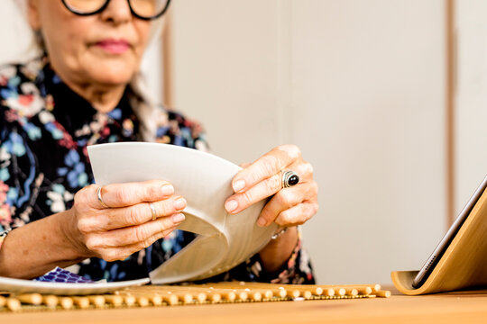 Portrait of hoary woman repairing a broken plate with a millenial japanese technique 