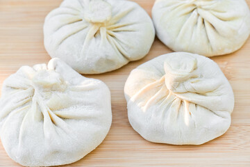 Fototapeta na wymiar Raw frozen dumplings. Uncooked dumplings or khinkali stuffed with meat ready for boiling.