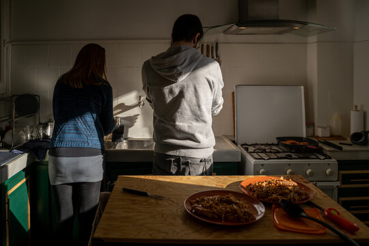 Couple cooking and cleaning kitchen