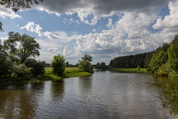 Fototapeta na wymiar Summer landscape with river and clouds. Sunny day..Summer rural landscape on a sunny day, beautiful clouds in the sky.