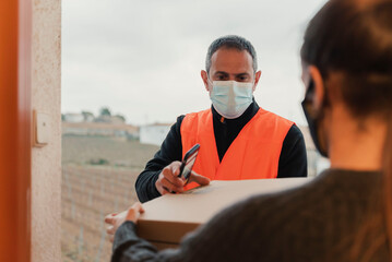 Delivery man with mask delivers package to customer.