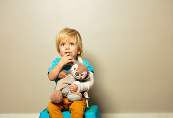 Boy with broken hand in plaster hug little rabbit