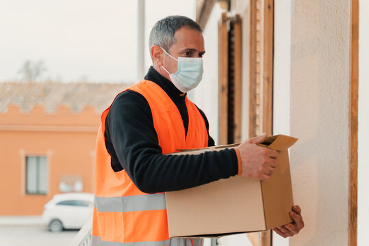 Delivery man with mask delivers package to customer.