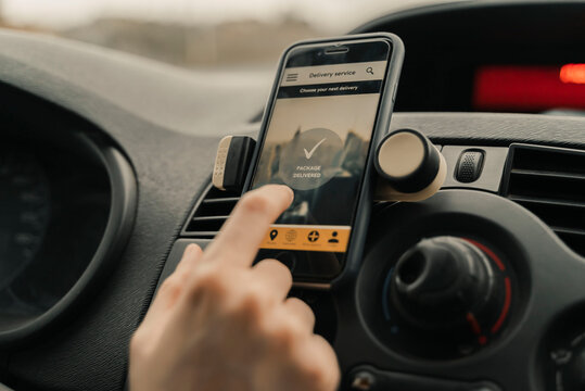 Close-Up Of Woman Using Delivery Application In Car.