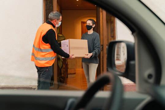 Delivery man with mask delivers package to customer.