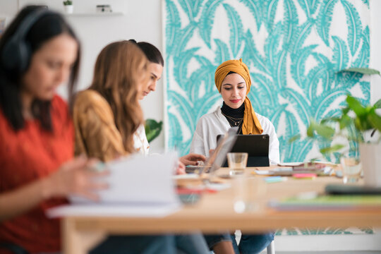 Multiracial Team Of Smart Female Entrepreneurs Working In Office Using Various Gadgets