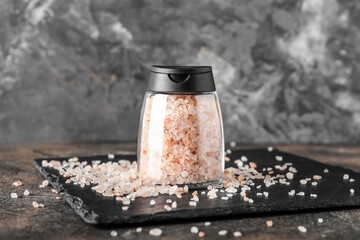 Jar with sea salt on grunge background