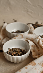 Obraz na płótnie Canvas Pile of dried green tea leaves in little bowls, white background, dried tea leaves