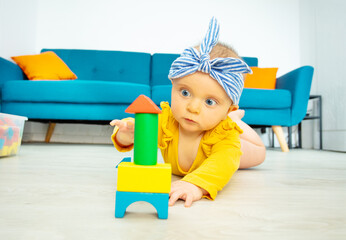 Little girl play with wooden blocks in living room