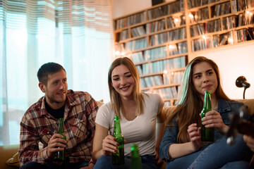 Friends on a house party having fun and drinking beer
