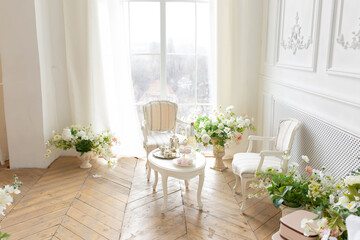  white set of chairs and a table by the window. furniture in classic style. tea table by the window