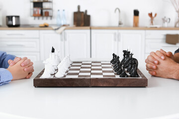 Father and son playing chess in kitchen, closeup