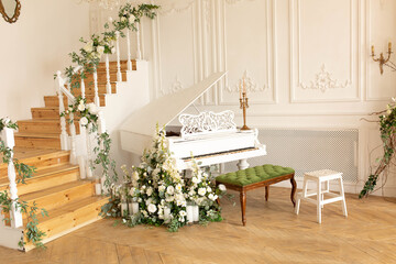 white piano by a wooden staircase decorated with flowers