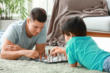 Father and son playing chess at home