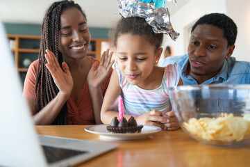 Family celebrating birthday online at home.