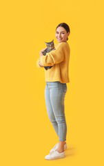 Fototapeta na wymiar Beautiful young woman with cute cat on color background