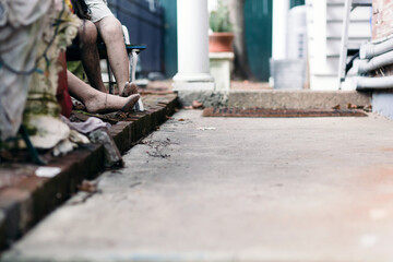 Decaying mannequin legs and feet alongside a sidewalk.