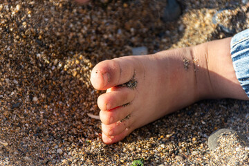 Close up of baby foot fingers on the beach.