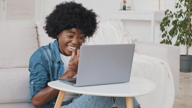 Happy overjoyed African woman read great news feel good surprise about job opportunity. Student girl get online test result scholarship on computer feel winner using look at laptop celebrate success